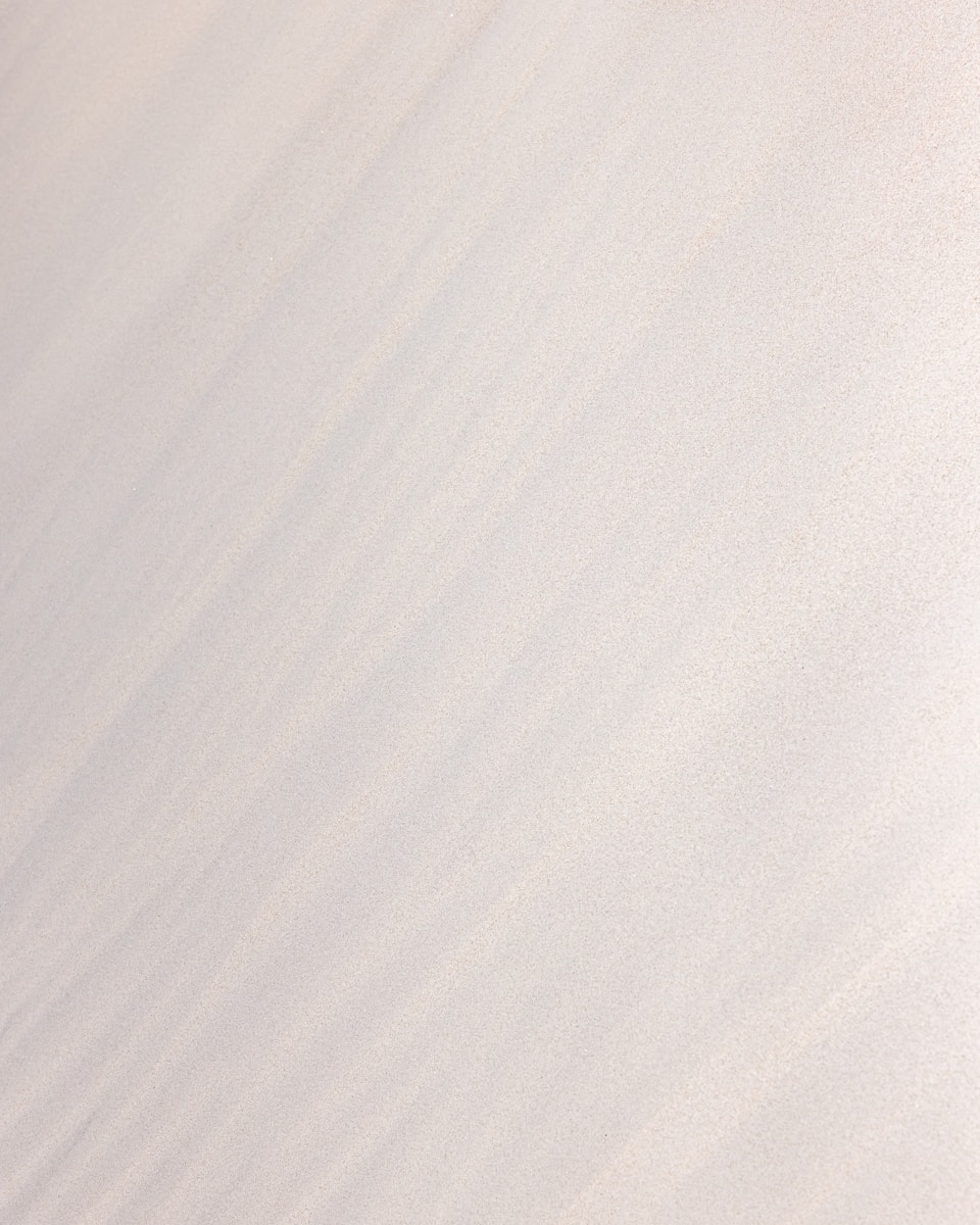 a man riding a snowboard down the side of a snow covered slope